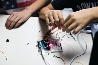 A person connecting wires to an Arduino